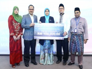 Azlan (dua dari kiri) menyerahkan sumbangan cek RM100,000 kepada Dr Siti Zaleha (tengah)