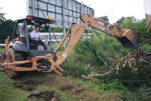 黄瑞林驾驶推泥机协助承包商清理沟里的垃圾。