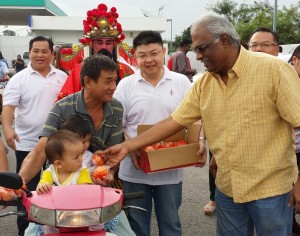 巴生区国会议员查尔斯（右起）连同班达马兰区州议员陈博雄，派年柑向选民拜年。