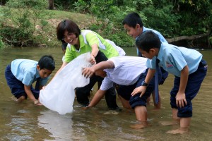李继香与学生们一起把鱼苗放生如吉粦河内。