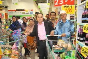 黄瑞林（中）陪同穆斯林家庭前往巨人霸级市场购物。右二为双溪拉姆村长罗志坚。