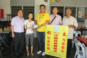 王儒强（中）在黄瑞林（左）的见证下，移交2200令吉捐款给王珊珊。右起为谢明俊及范少楠。