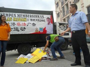 黄田志（右）在无拉港州选区展开拆除非法宣传品运动。