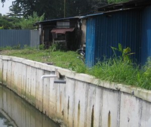 业者凿开沟墙，装置厕所排污水管。
