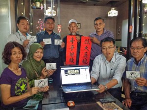 李凯伦（坐者右二）与大山脚公正党领袖和支持者一起推介“释放安华”（Bebas Anwar）面子书照片徽章。