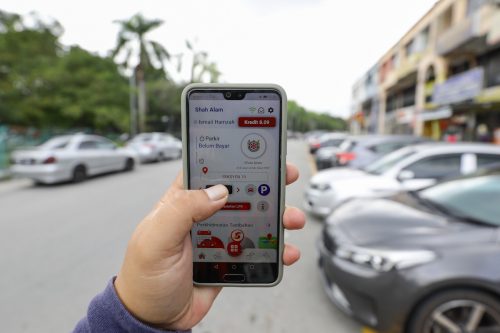 Ismail Hamzah, 27, menggunakan aplikasi Smart Selangor Parking (SSP) ketika tinjauan Media Selangor di Seksyen 19, Shah Alam pada 10 Januari 2022. Foto FIKRI YUSOF/SELANGORKINI